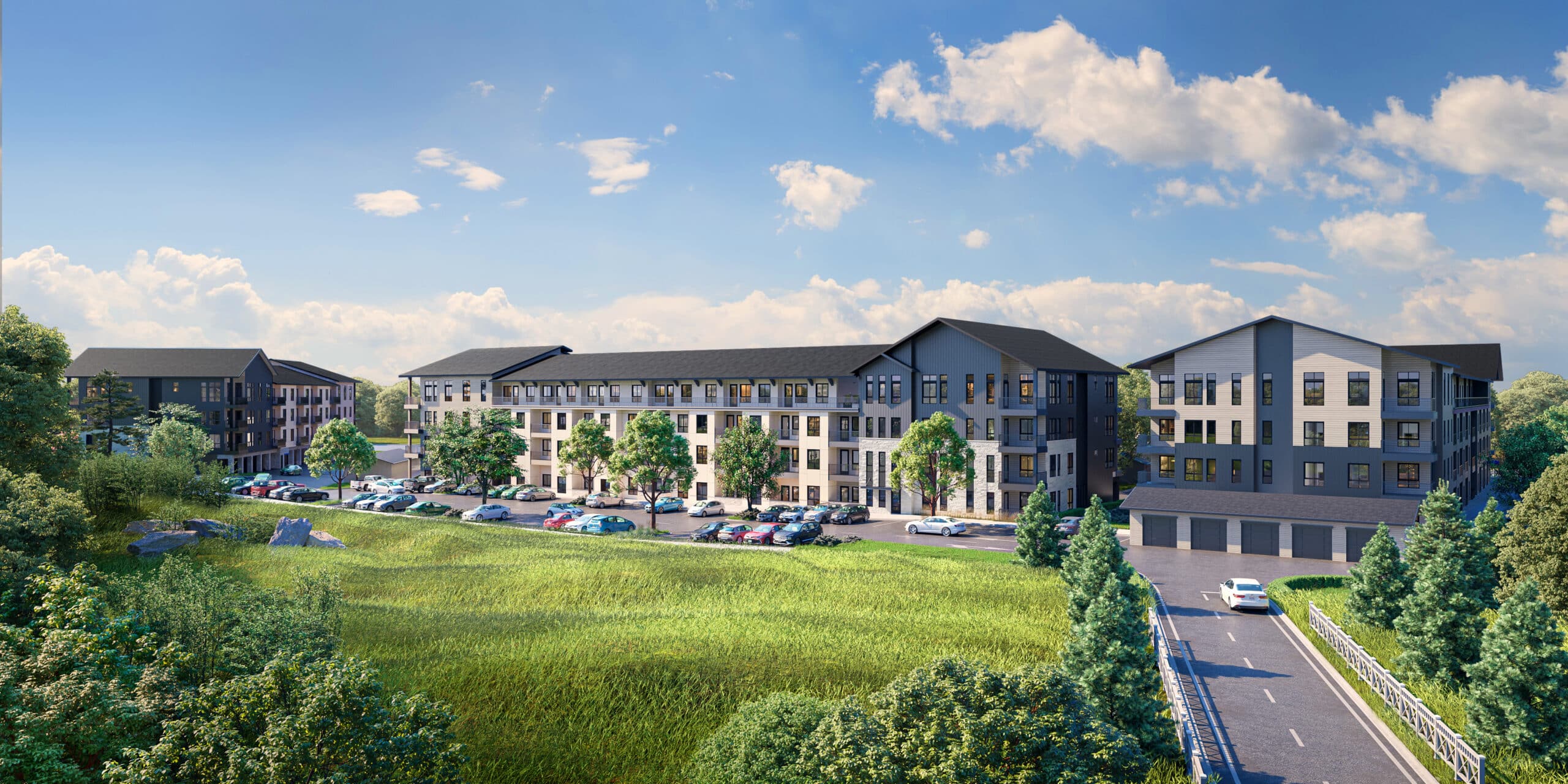 The exterior of a four-story apartment building with white and blue walls and a black roof surrounded by grass and trees under a blue sky.
