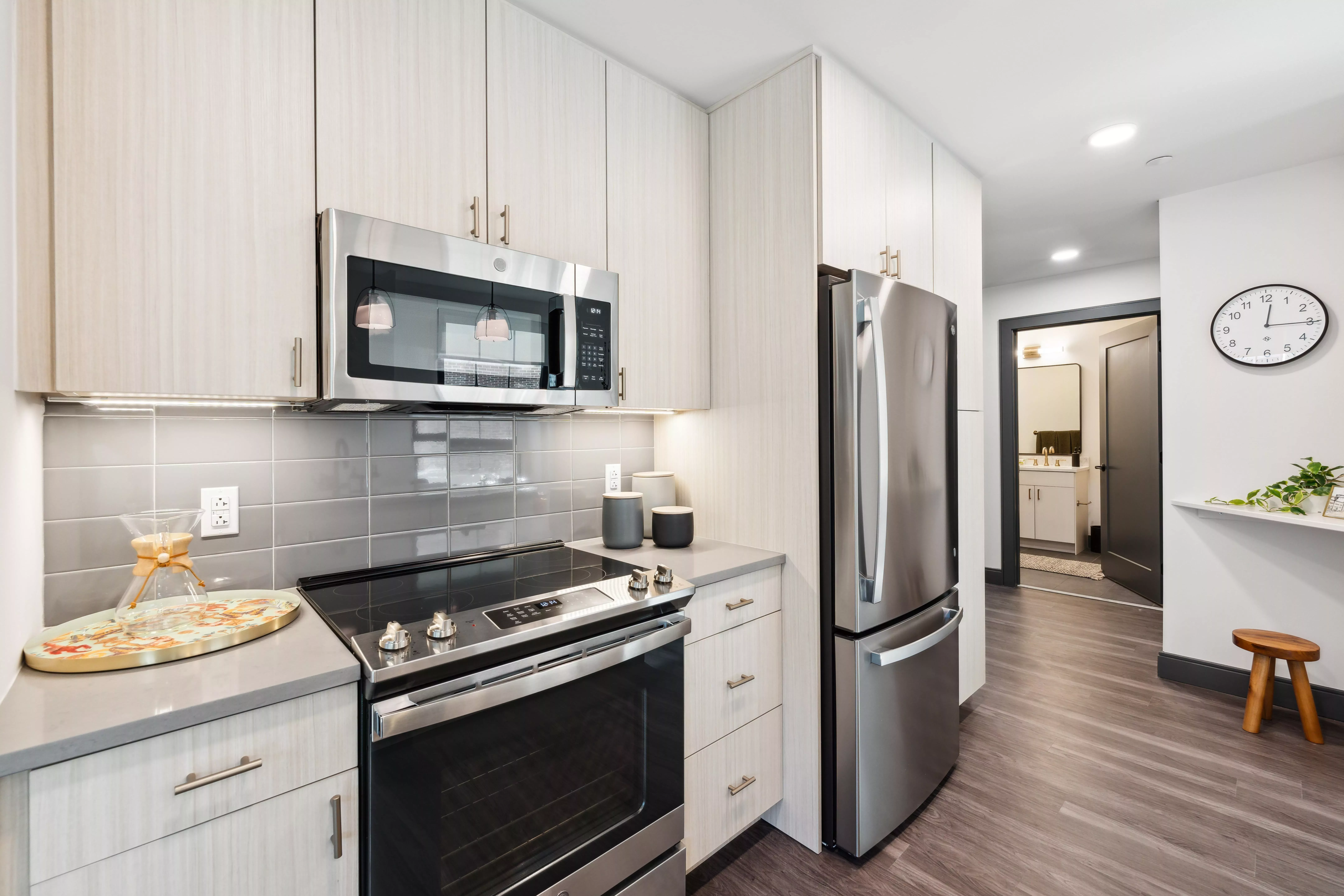 Kitchen with light color cabinets, dark wood-style floors, and stainless steel appliances