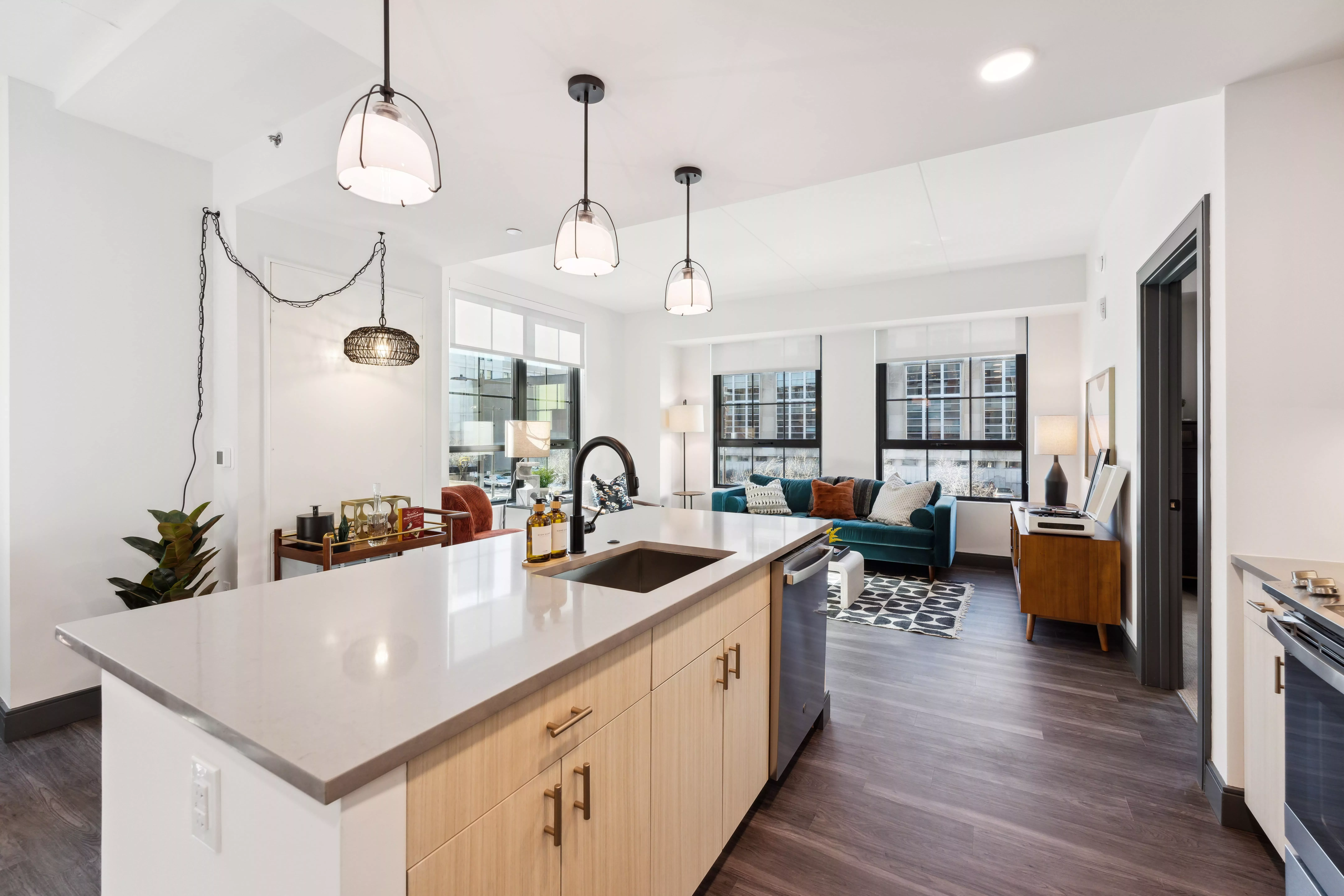 Kitchen with center island with sink overlooking the living room with large windows