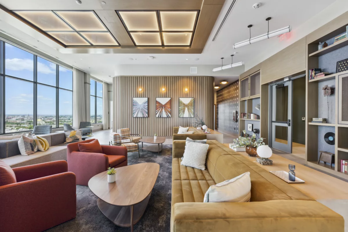 Rooftop lounge with couches, booth seating, and large windows with city views