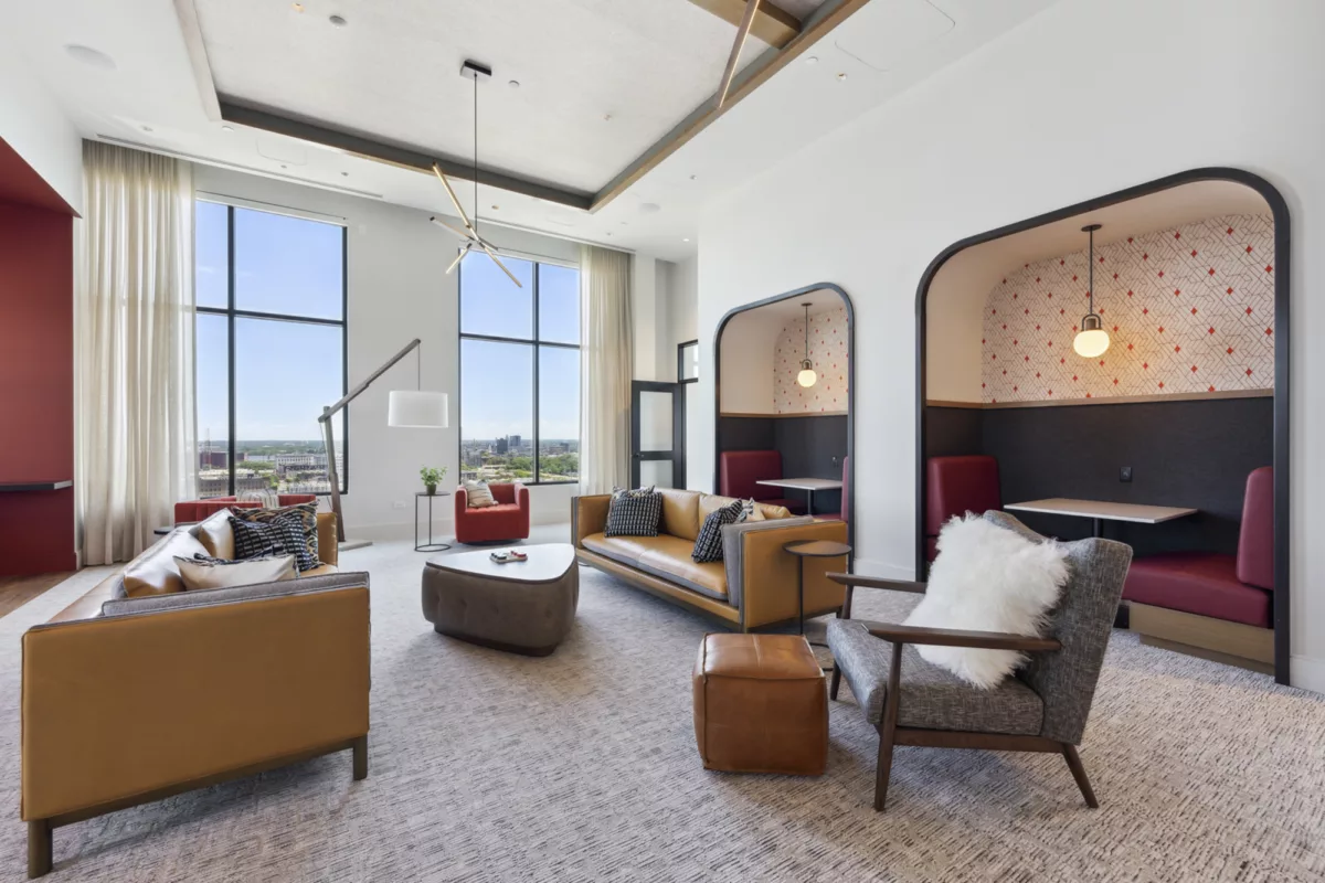 Rooftop would with couches and armchairs, booth seating, and large windows with city views