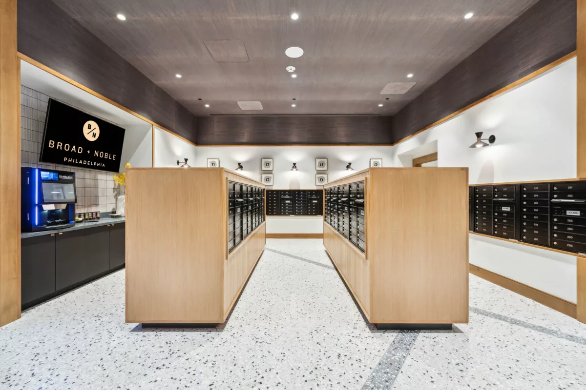 Mail room with black mailboxes, marble floor, and coffee bar and TV screen